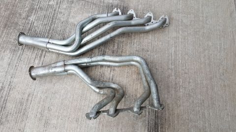 1973 Ford F-100 - A pair of silver exhaust headers are shown resting on a concrete surface.
