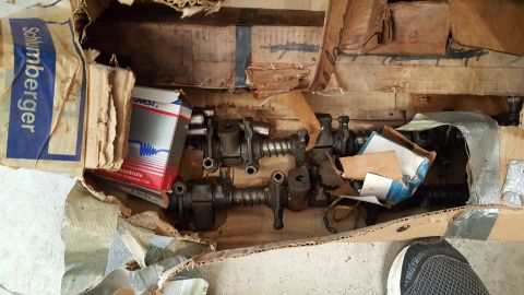 1973 Ford F-100 - Engine parts, possibly rocker arms and pushrods, are stored in cardboard boxes. One box is labeled 'QUEST CONTROLS'.