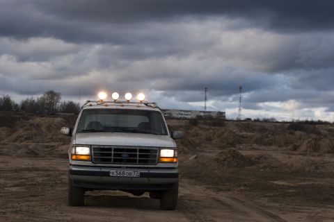 1993 Ford Bronco - A white Ford F-Series truck is parked on a dirt road under a cloudy sky.