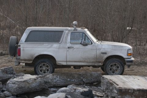 1993 Ford Bronco - This 1993 Ford Bronco is shown in a side profile, parked amidst large rocks.