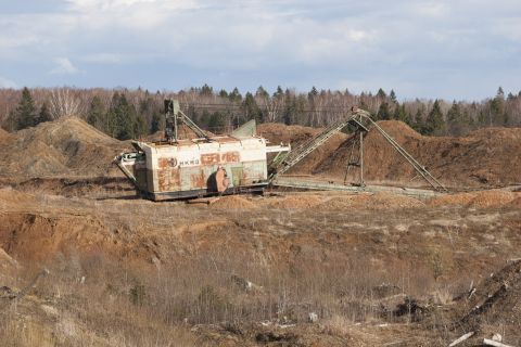 1993 Ford Bronco - An old, rusty excavator sits in a dirt quarry with trees in the background.