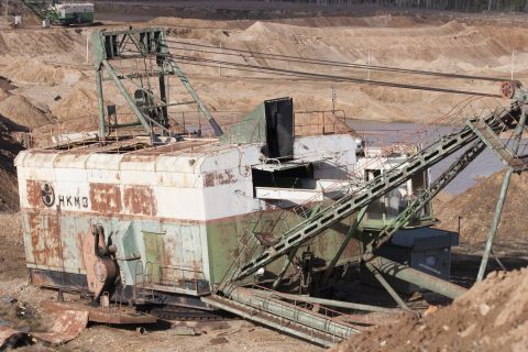 1993 Ford Bronco - A massive, rusty excavator sits in a quarry, with another machine visible in the distance.
