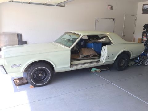 1968 Mercury Cougar - This vintage coupe is in a garage, showing its interior and side profile with doors ajar.