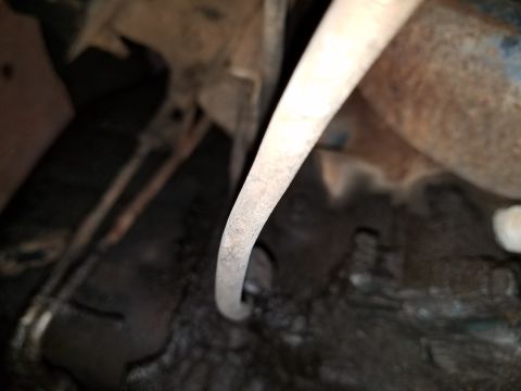 1971 Ford Mustang - Close-up view of the undercarriage of a vehicle, focusing on the exhaust system and frame.