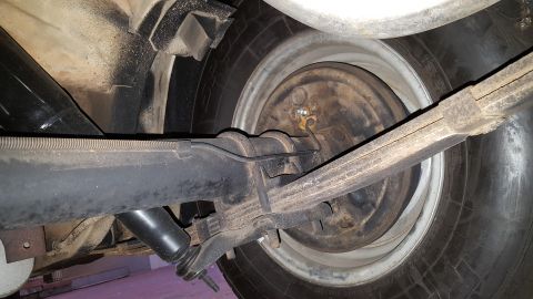 1971 Ford Mustang - Close-up view of a vehicle's rear axle, leaf spring, and drum brake components.