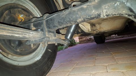 1971 Ford Mustang - A close-up shot of the rear suspension system of a vehicle, showing the leaf springs and shock absorber.
