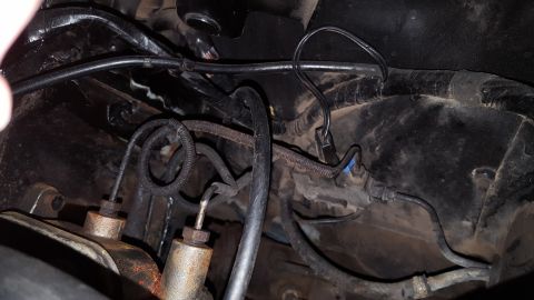 1971 Ford Mustang - Close-up view of brake system components, including lines and master cylinder, in a vehicle's engine bay.