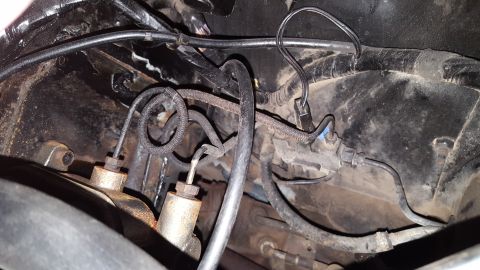 1971 Ford Mustang - Close-up view of brake lines and wiring within the engine bay of a vehicle.