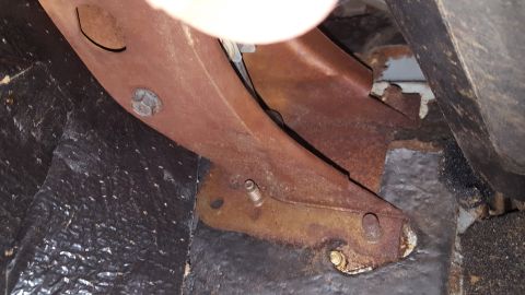 1971 Ford Mustang - Close-up view of a rusty metal bracket and floor insulation, with a SuperMotors logo visible at the bottom right.