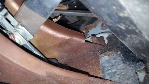 1971 Ford Mustang - Close-up view of rusted metal parts and undercarriage components, likely from a vehicle.