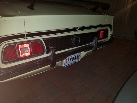 1971 Ford Mustang - Rear view of a 1971 Ford Mustang, its distinctive taillights, black stripe detail, and rear spoiler.