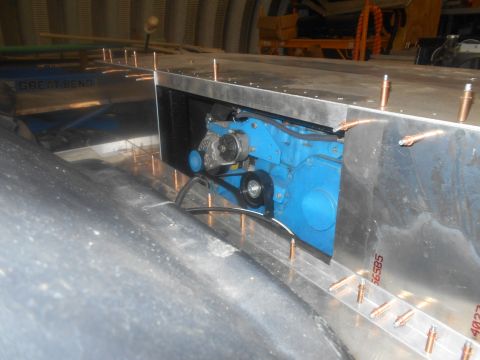 1992 Ford Bronco - A close-up view of a blue engine component with a belt and pulley system, installed within a metallic structure.