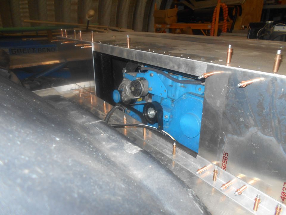 Blue engine component with belt and pulley system, partially enclosed in metal housing with copper rivets