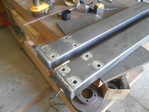 1992 Ford Bronco - Metal frame parts are prepared on a workbench with tools and a brake rotor nearby.
