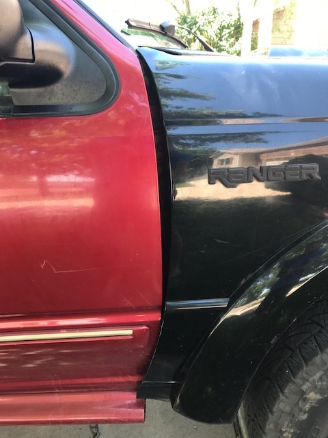 2000 Ford Explorer - Close-up of a two-tone pickup truck showing the seam between the door and fender.