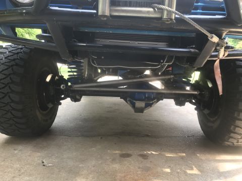 1974 Ford Bronco - This photo shows the undercarriage of a modified off-road vehicle, focusing on the suspension and drivetrain components.