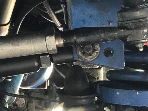 1974 Ford Bronco - Detail of vehicle steering and suspension parts, showing a blue bracket and metal linkage.