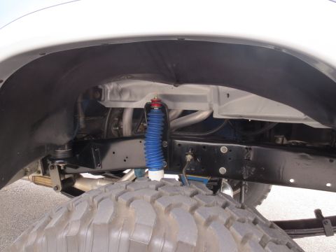 1967 Ford F-250 - This image shows the undercarriage of a truck, focusing on the suspension and a large tire.