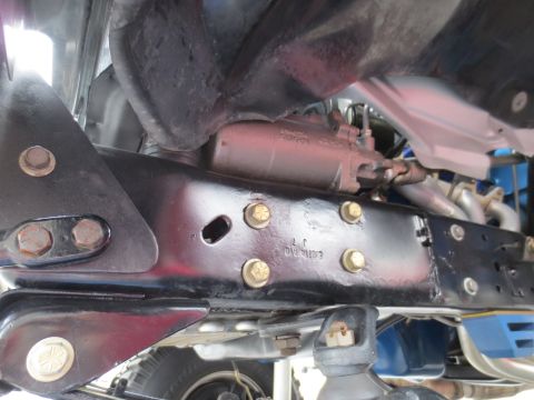 1967 Ford F-250 - Close-up of the undercarriage reveals steering components and frame structure, with some stamped markings visible.