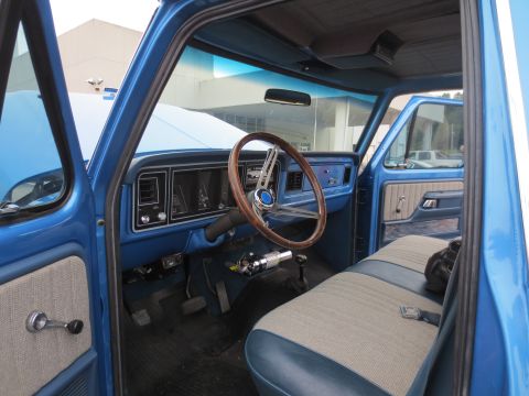 1967 Ford F-250 - Interior view of a blue pickup truck, showing the dashboard, steering wheel, and seats.