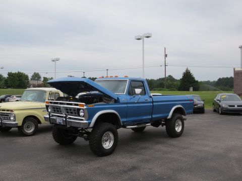 1967 Ford F-250 - This blue Ford F-250 pickup truck appears to be from the mid-1970s, with its hood raised for inspection.