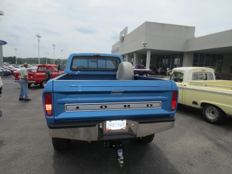 1967 Ford F-250 - This blue 1967 Ford F-250 pickup truck is seen from the rear, parked in a lot with other vehicles.