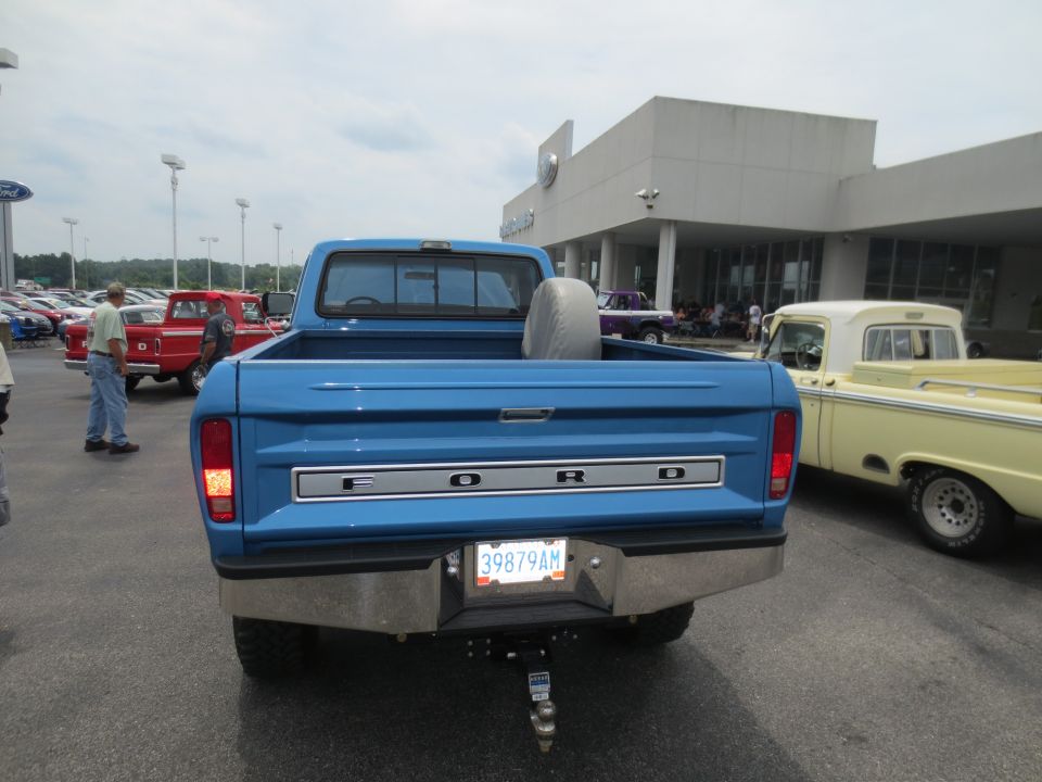 Rear view of blue 1967 Ford F-250 with chrome bumper and spare tire in bed