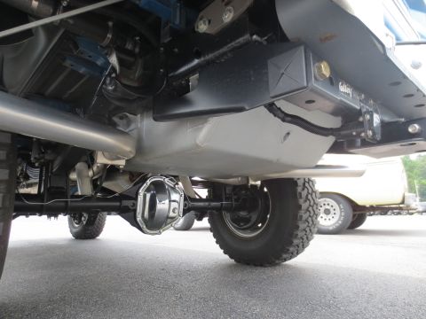 1967 Ford F-250 - Undercarriage detail of a truck, with a second vehicle visible behind it the background.