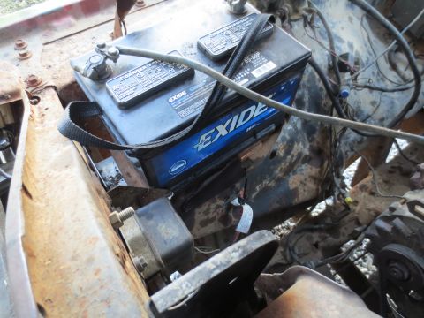 1967 Ford F-250 - A close-up view of a vehicle's battery and surrounding engine compartment components.