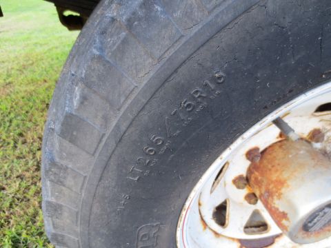 1967 Ford F-250 - Close-up of a worn tire and rusty wheel, showing tire size LT265/75R16.