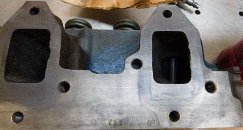 1968 Mercury Cougar - Close-up of an engine cylinder head, showing intake and exhaust ports and stamped numbers.