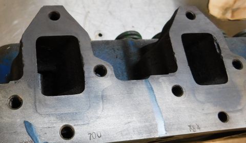 1968 Mercury Cougar - Close-up of an engine cylinder head, showing intake ports and mounting holes with some markings.