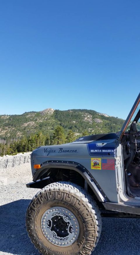 1979 Ford Bronco - A modified Ford Bronco sits on a dirt road, its off-road tires ready for adventure in a mountainous landscape.