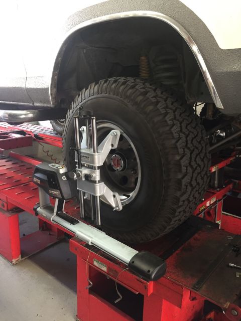 1978 Ford Bronco - A vehicle's front tire is being serviced by wheel alignment equipment.