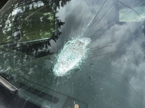 1993 Ford Bronco - The windshield of a vehicle shows significant damage from an impact, with glass shattered in a radial pattern.
