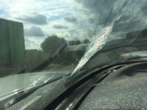 1993 Ford Bronco - Interior view of a vehicle's cracked windshield, with a green structure visible in the background.