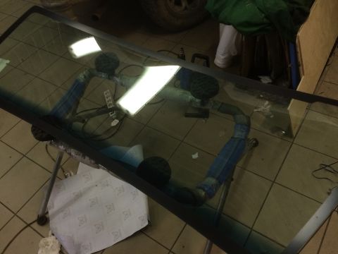 1993 Ford Bronco - Windshield is propped up on a stand in what appears to be a workshop.