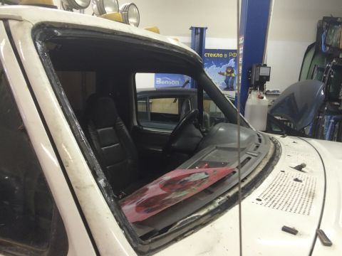 1993 Ford Bronco - The interior of a white Ford Bronco is shown with the windshield removed, ready for replacement.