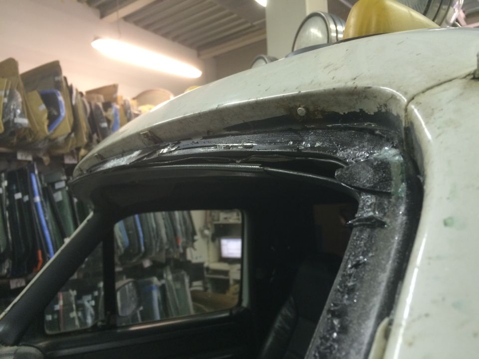 White vehicle windshield frame with damaged sealant