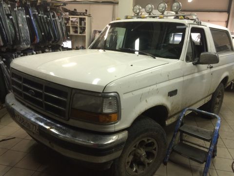1993 Ford Bronco - This white Ford Bronco is parked inside a garage with a ladder nearby.