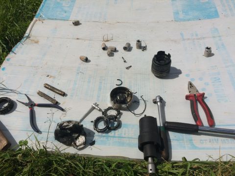 1993 Ford Bronco - Various vehicle parts and tools are spread out on a tarp, suggesting a repair or maintenance process.