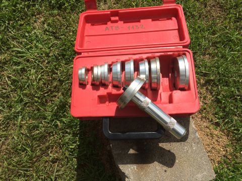 1993 Ford Bronco - A red plastic case holds a set of bearing race and seal drivers, with one tool resting outside the case.