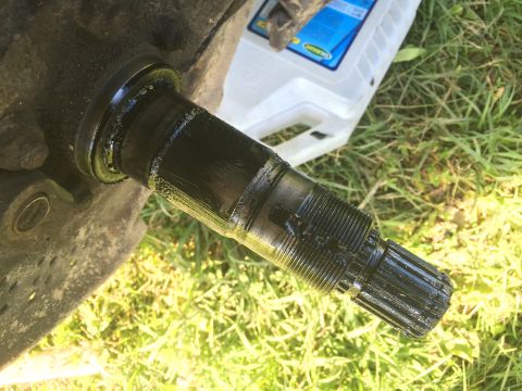 1993 Ford Bronco - Close-up of a greasy axle shaft, likely from a vehicle's drivetrain.