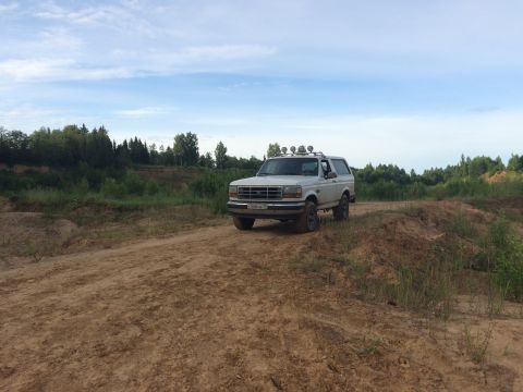 1993 Ford Bronco - This 1993 Ford Bronco is parked on a dirt road with a wooded area behind it.