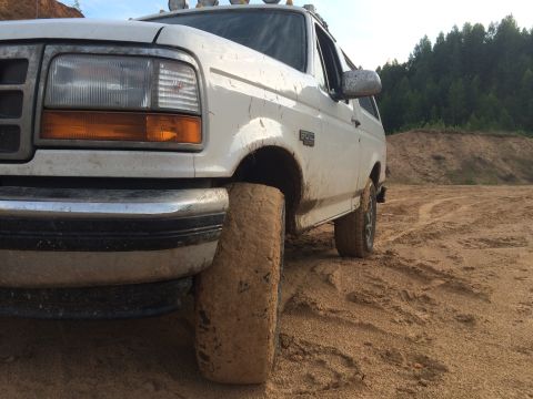 1993 Ford Bronco - This 1993 Ford Bronco is shown off-road with its front tire stuck in the dirt.