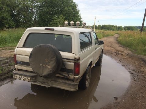 1993 Ford Bronco - This 1992 Ford Bronco is seen from the rear, partially submerged in a muddy puddle on a rural dirt road.