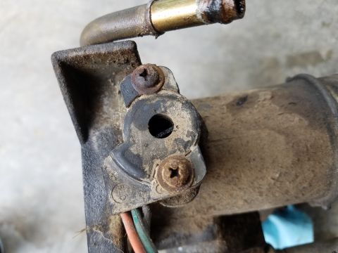 1995 Ford Bronco - This is a close-up view of a dirty automotive component, showing a metal hose and electrical wires.