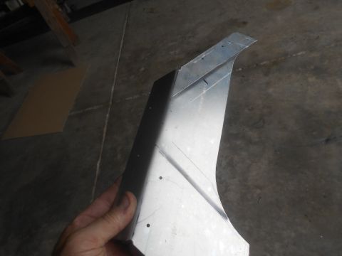 1992 Ford Bronco - A piece of sheet metal is held up, showing its bent and formed shape.