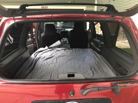 2000 Ford Explorer - Rear view of a 2000 Ford Explorer's interior, showing the cargo space prepared for sleeping.