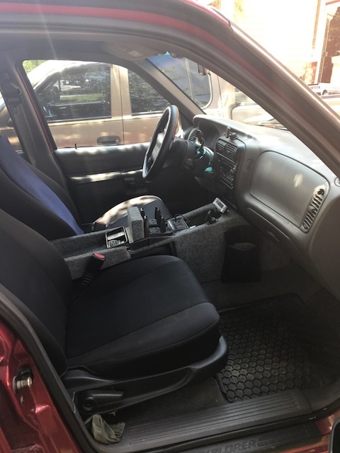 2000 Ford Explorer - The interior of a vehicle is shown, with a focus on the front seats and dashboard area around the steering wheel.